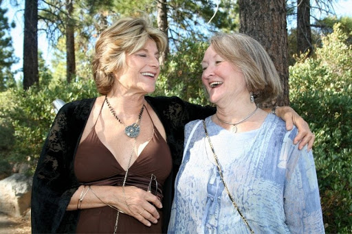 two older women holding each other and laughing