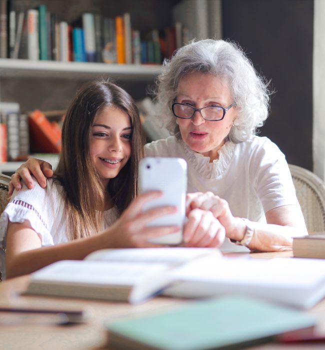 An older woman smiling and talking to her granddaughter while taking inventory for her estate plan