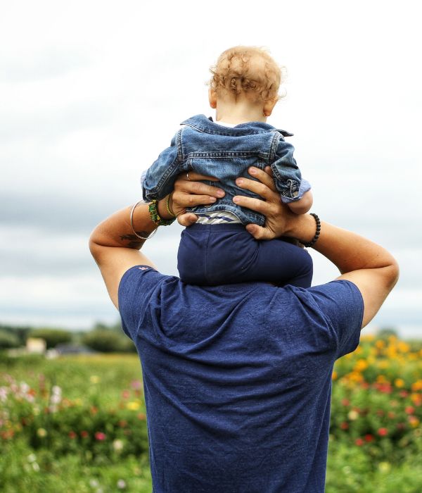 A man holding a small child on his shoulders